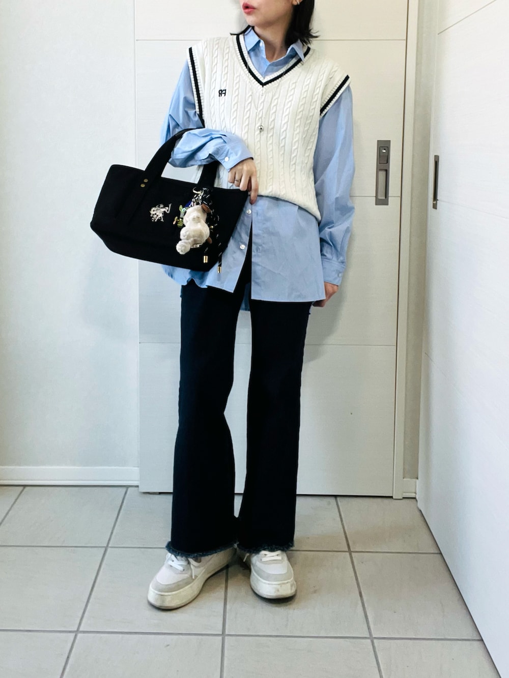 ホワイト系のベスト、ブルー系のシャツ/ブラウス、ブルー系のデニムパンツを着用したレディースの春コーディネートの4枚目の写真