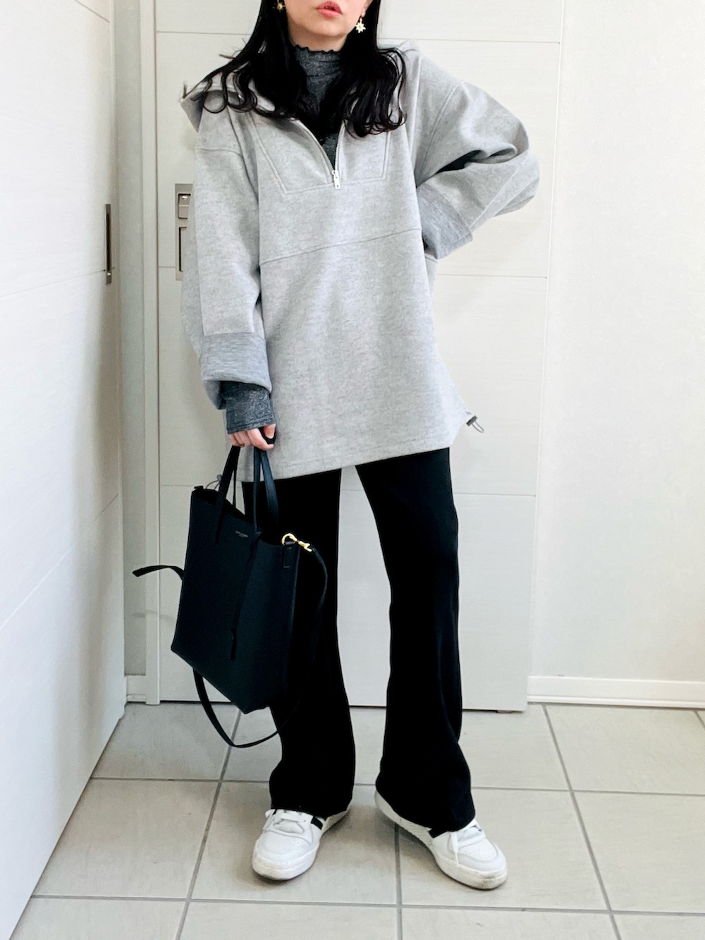 グレー系のパーカー、グレー系のTシャツ/カットソー、ブラック系のスラックスを着用したレディースの冬コーディネートの4枚目の写真