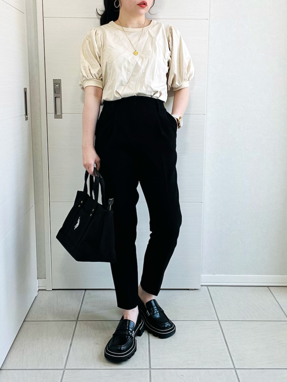 ベージュ系のTシャツ/カットソー、ブラック系のパンツ、ブラック系のローファーを着用したレディースの春コーディネートの2枚目の写真