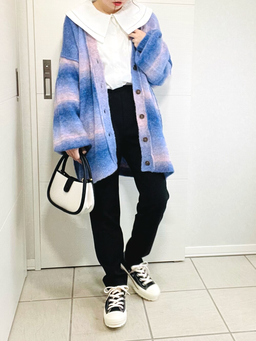 ブルー系のカーディガン/ボレロ、ホワイト系のシャツ/ブラウス、ブラック系のその他パンツを着用したレディースの秋コーディネートの3枚目の写真