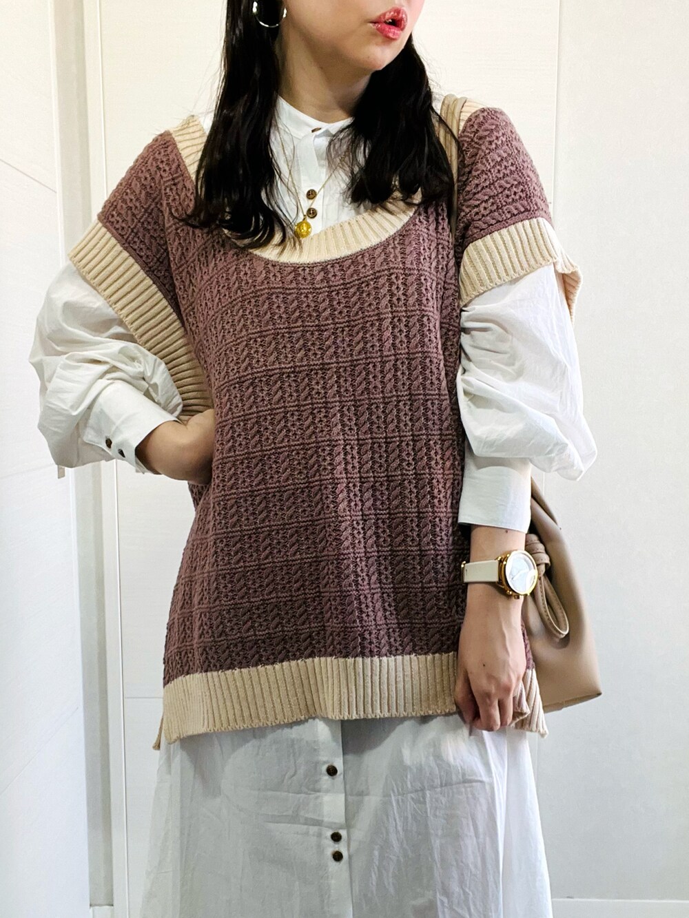 ブラウン系のベスト、ホワイト系のワンピース、ベージュ系のスニーカーを着用したレディースの秋コーディネートの3枚目の写真