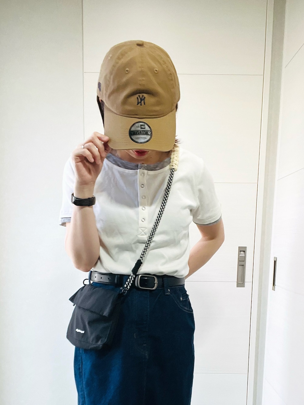 ホワイト系のTシャツ/カットソー、ブルー系のスカート、グレー系のスニーカーを着用したレディースの春コーディネートの2枚目の写真