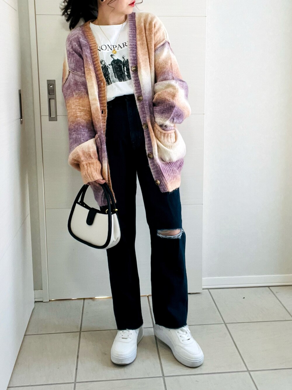 ブラウン系のカーディガン/ボレロ、ホワイト系のTシャツ/カットソー、ブルー系のデニムパンツを着用したレディースの冬コーディネートの4枚目の写真