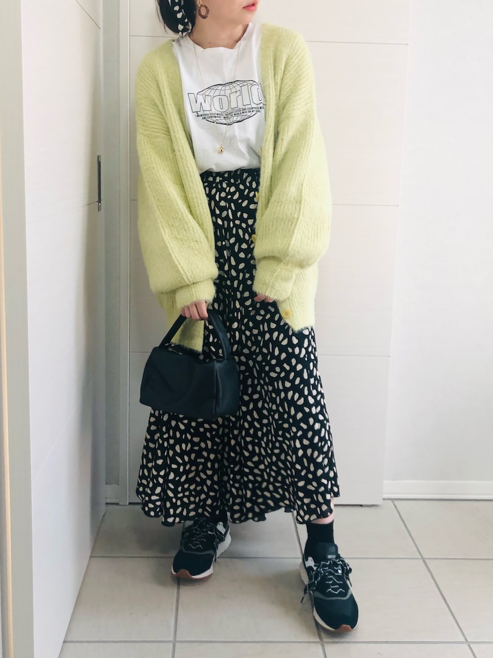 グリーン系のカーディガン/ボレロ、ホワイト系のTシャツ/カットソー、ブラック系のスニーカーを着用したレディースの秋コーディネートの3枚目の写真