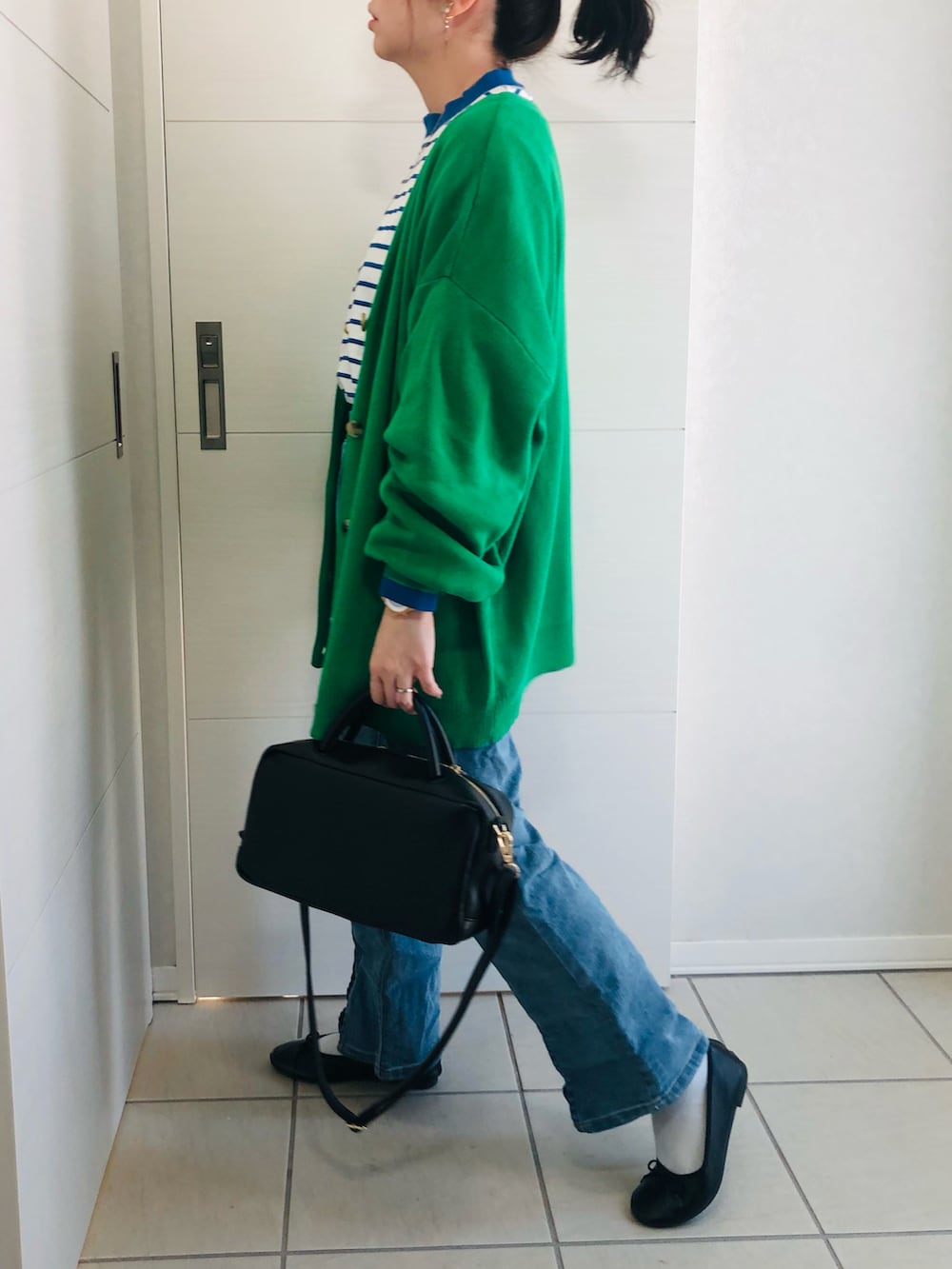 グリーン系のカーディガン/ボレロ、ブルー系のTシャツ/カットソー、ブルー系のデニムパンツを着用したレディースの冬コーディネートの4枚目の写真