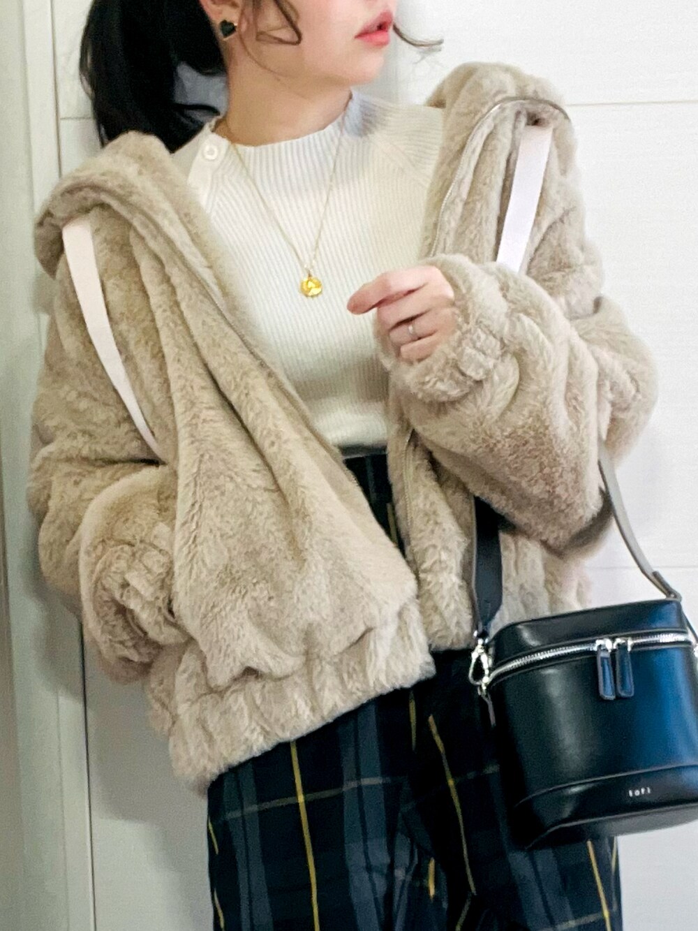 ベージュ系のブルゾン、ブラック系のスカート、ブラック系のスニーカーを着用したレディースの冬コーディネートの2枚目の写真