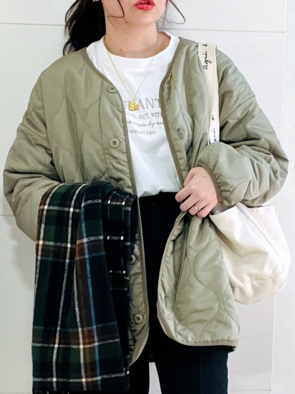 ホワイト系のTシャツ/カットソー、グリーン系のノーカラージャケット、ブラック系のスラックスを着用したレディースの冬コーディネートの3枚目の写真