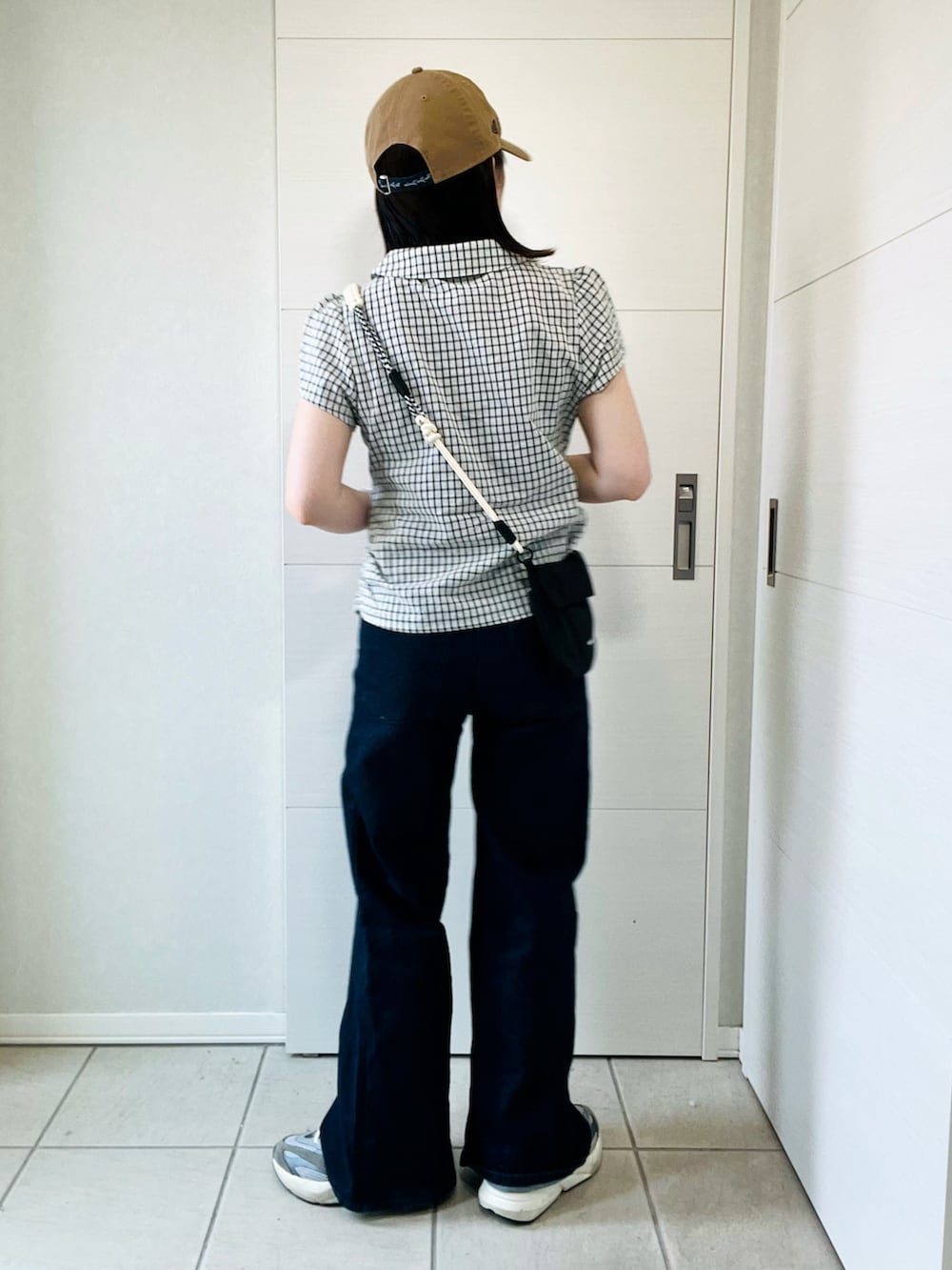 ホワイト系のシャツ/ブラウス、グレー系のスニーカー、ブラック系のショルダーバッグを着用したレディースの夏コーディネートの5枚目の写真