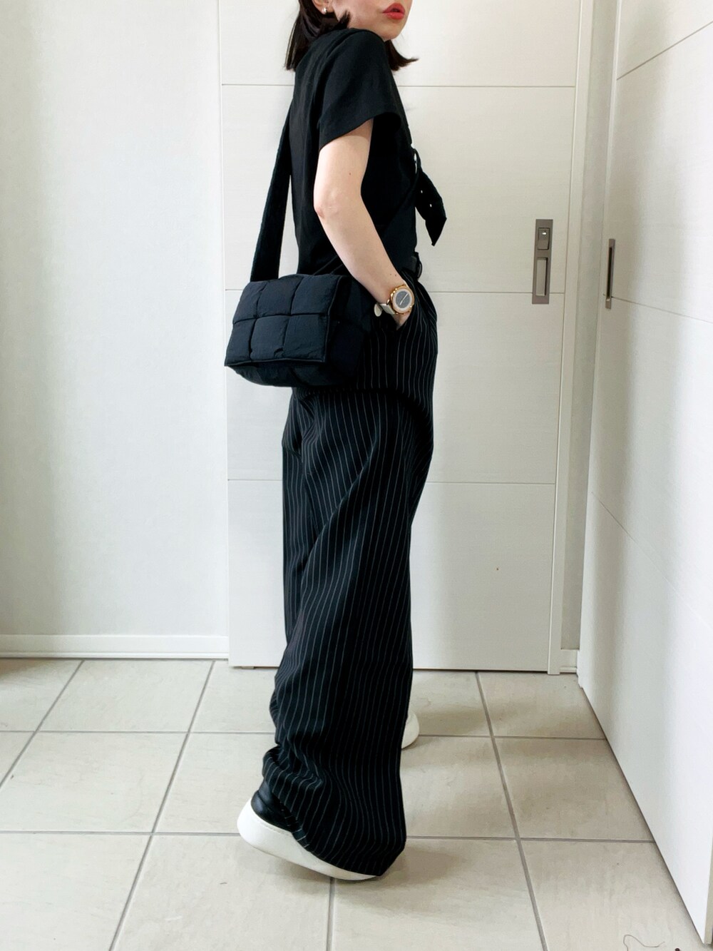 ブラック系のデニムパンツ、ブラック系のTシャツ/カットソー、ブラック系のスニーカーを着用したレディースの秋コーディネートの5枚目の写真