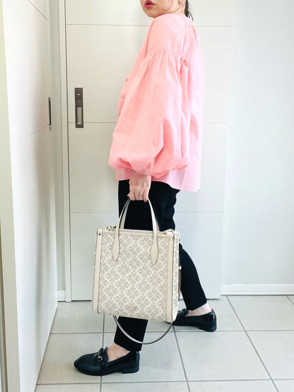 ピンク系のシャツ/ブラウス、ホワイト系のTシャツ/カットソー、ブラック系のパンツを着用したレディースの春コーディネートの5枚目の写真