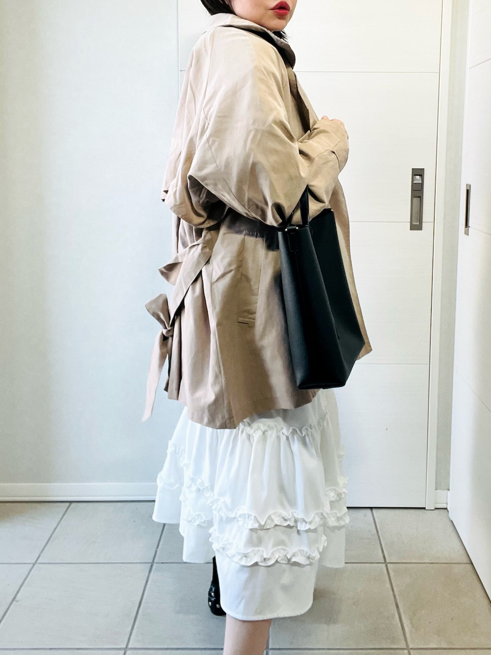 ベージュ系のトレンチコート、ブルー系のシャツ/ブラウス、ホワイト系のスカートを着用したレディースの春コーディネートの3枚目の写真