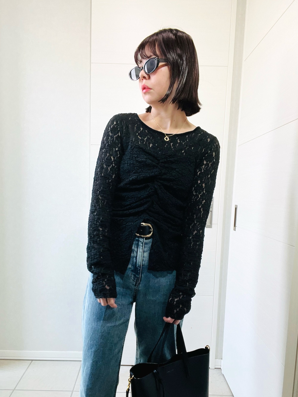 ブラック系のシャツ/ブラウス、ブラック系のブーツ、ブルー系のデニムパンツを着用したレディースの秋コーディネートの2枚目の写真
