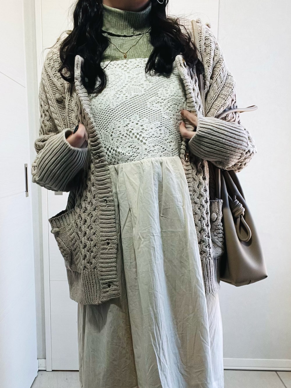 ホワイト系のワンピース、グリーン系のTシャツ/カットソー、ベージュ系のカーディガン/ボレロを着用したレディースの冬コーディネートの2枚目の写真