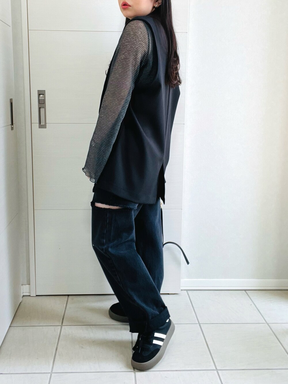 グレー系のTシャツ/カットソー、ブラック系のベスト、ブラック系のデニムパンツを着用したレディースの春コーディネートの5枚目の写真