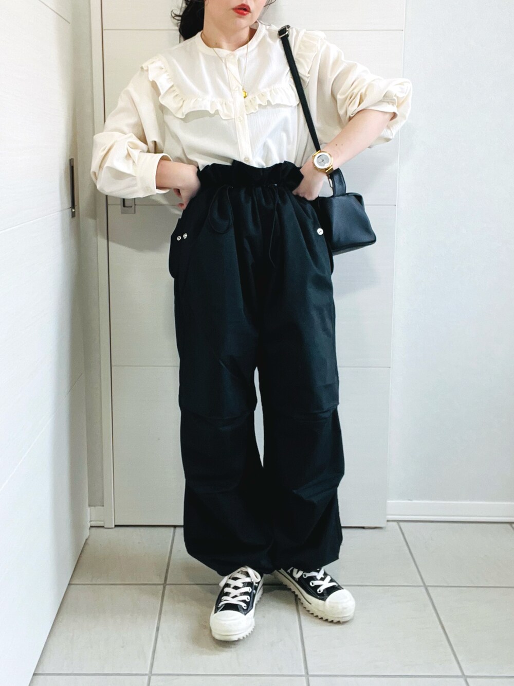 ブラック系のカーゴパンツ、ホワイト系のシャツ/ブラウス、ブラック系のスニーカーを着用したレディースの春コーディネートの2枚目の写真