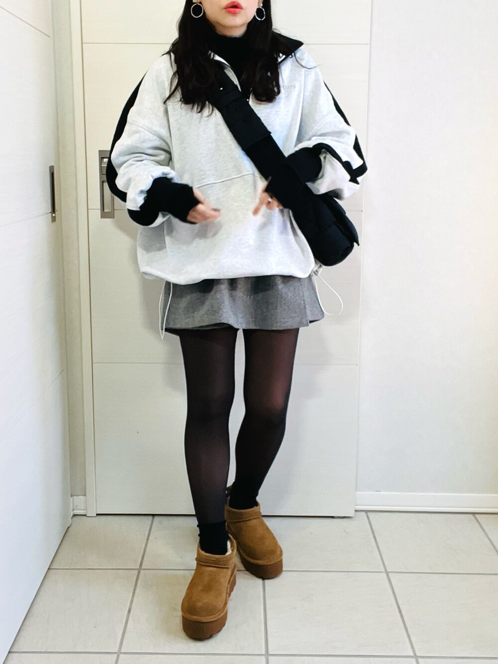 グレー系のスウェット、ブラック系のニット/セーター、グレー系のその他パンツを着用したレディースの冬コーディネートの4枚目の写真