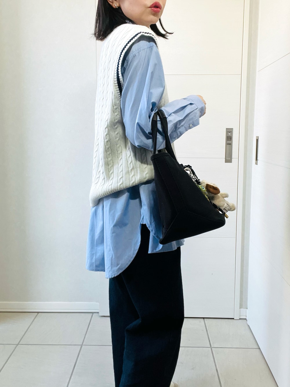 ホワイト系のベスト、ブルー系のシャツ/ブラウス、ブルー系のデニムパンツを着用したレディースの春コーディネートの3枚目の写真