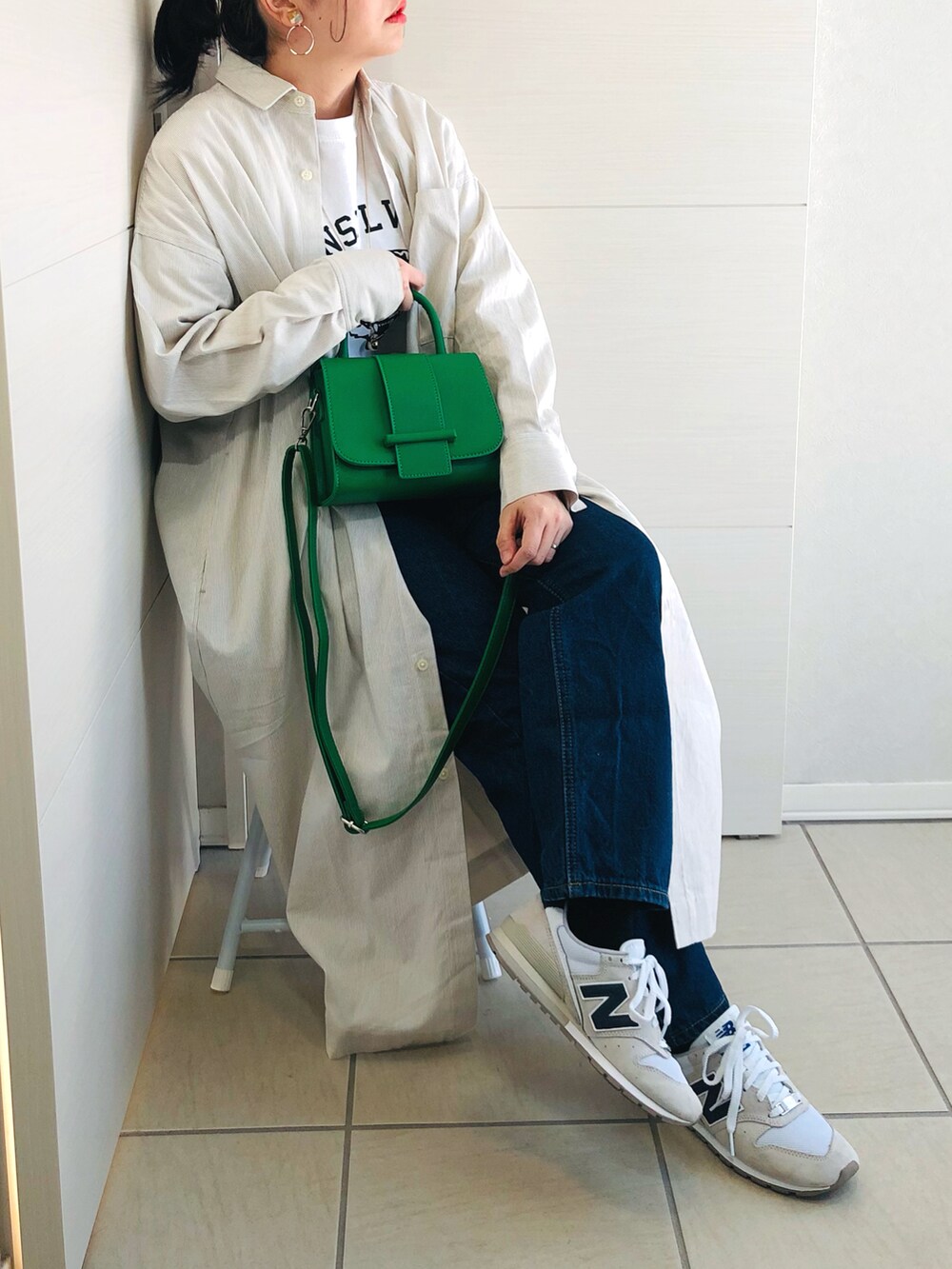 ベージュ系のワンピース、ホワイト系のTシャツ/カットソー、ブルー系のデニムパンツを着用したレディースの冬コーディネートの5枚目の写真