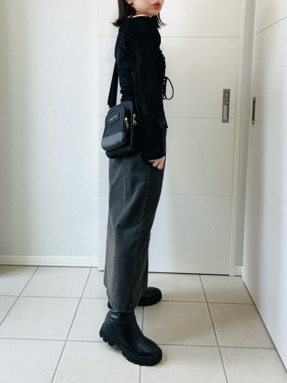 ブラック系のTシャツ/カットソー、ブラック系のブーツ、ブラック系のスカートを着用したレディースの秋コーディネートの5枚目の写真