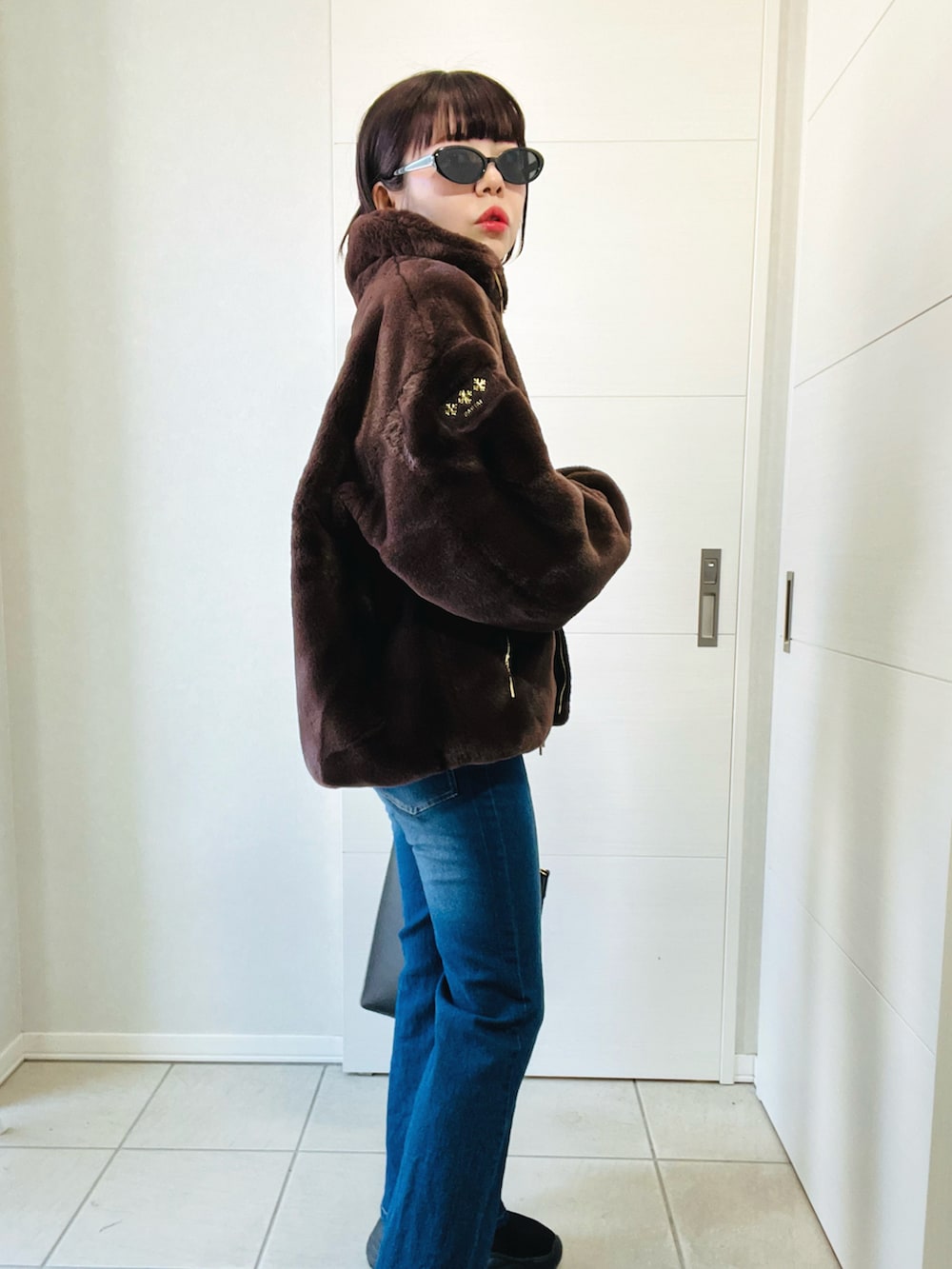 ブラウン系のジャケット/アウター、ブルー系のデニムパンツ、ブラック系のブーツを着用したレディースの冬コーディネートの4枚目の写真