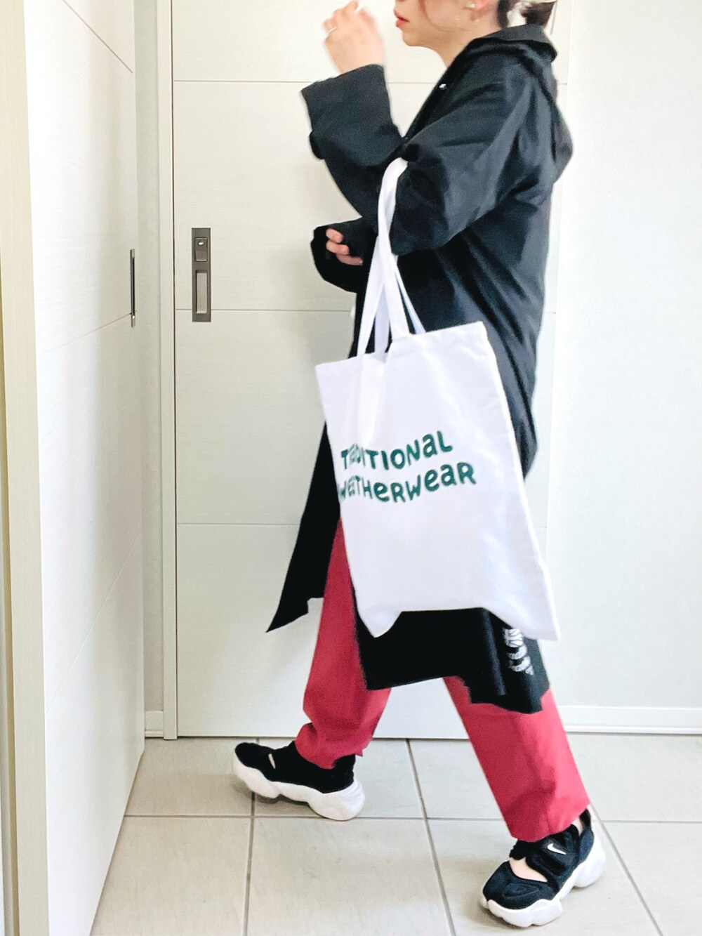 ホワイト系のTシャツ/カットソー、レッド系のスラックス、ブラック系のスニーカーを着用したレディースの春コーディネートの4枚目の写真