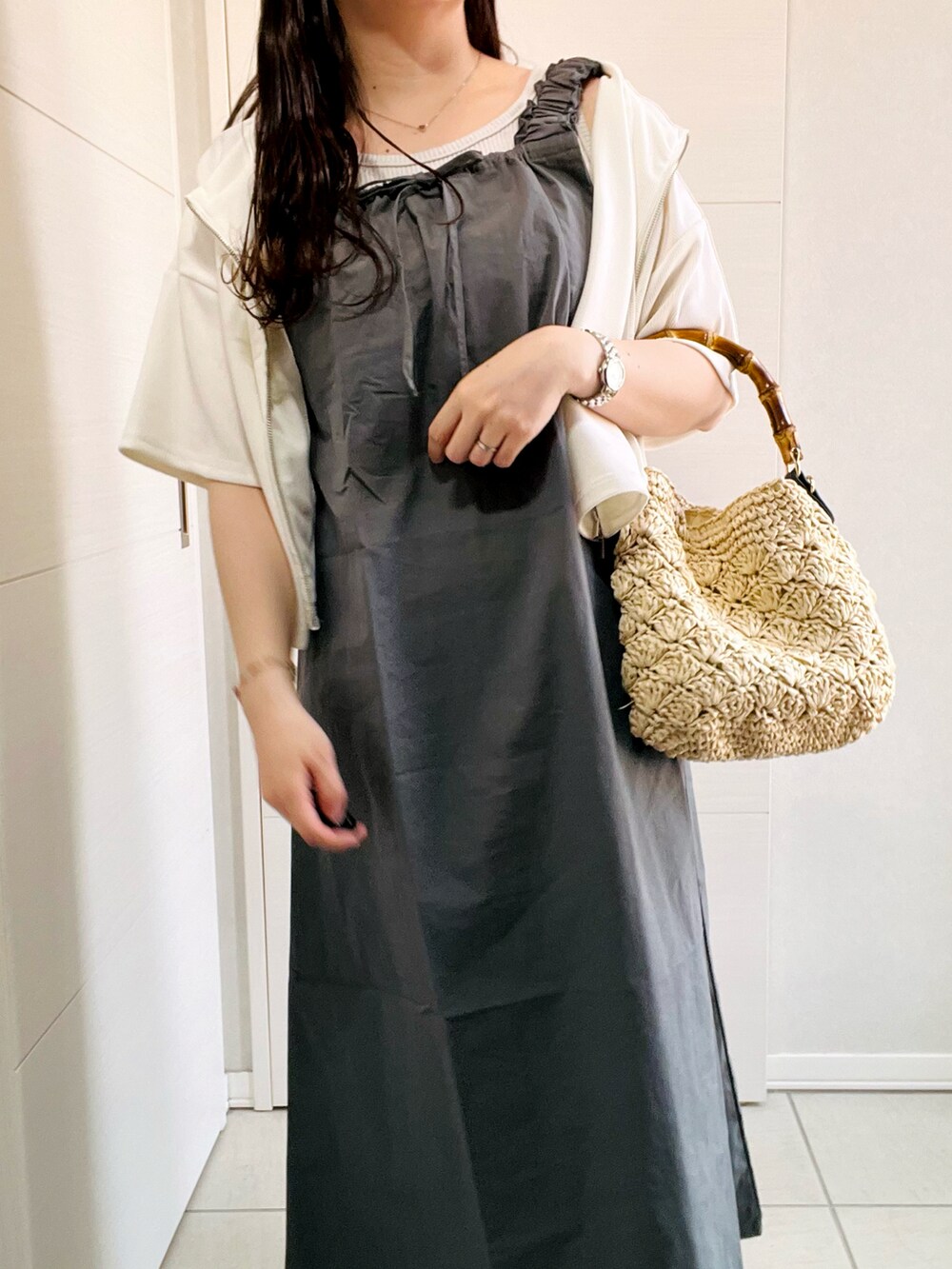 グレー系のワンピース、ブラック系のサンダル、ベージュ系のショルダーバッグを着用したレディースの夏コーディネートの2枚目の写真