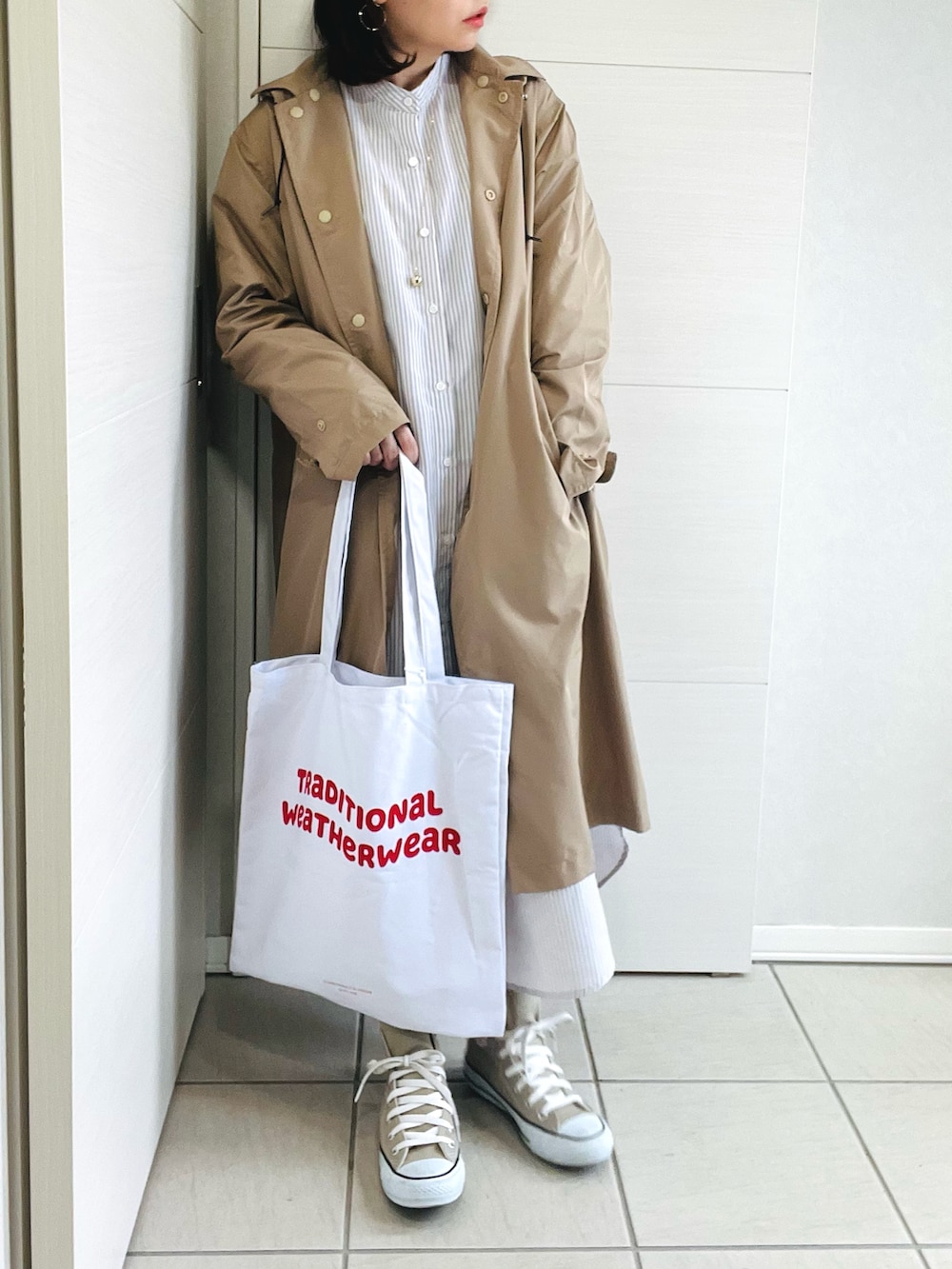 ベージュ系のシャツワンピース、ベージュ系のスニーカー、ホワイト系のトートバッグを着用したレディースの春コーディネートの2枚目の写真