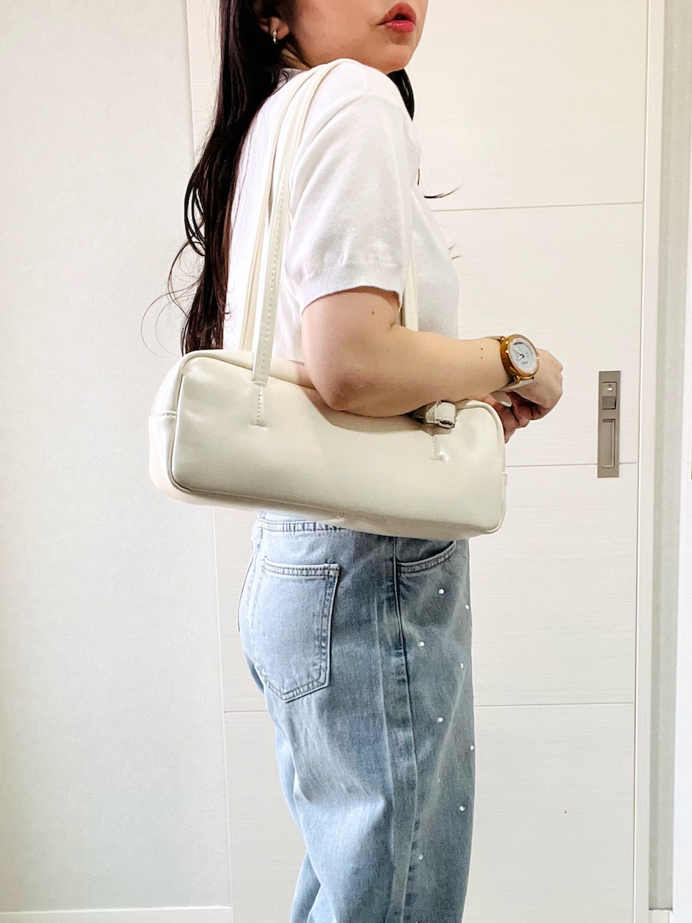 ホワイト系のニット/セーター、ブルー系のデニムパンツ、ホワイト系のスニーカーを着用したレディースの夏コーディネートの3枚目の写真