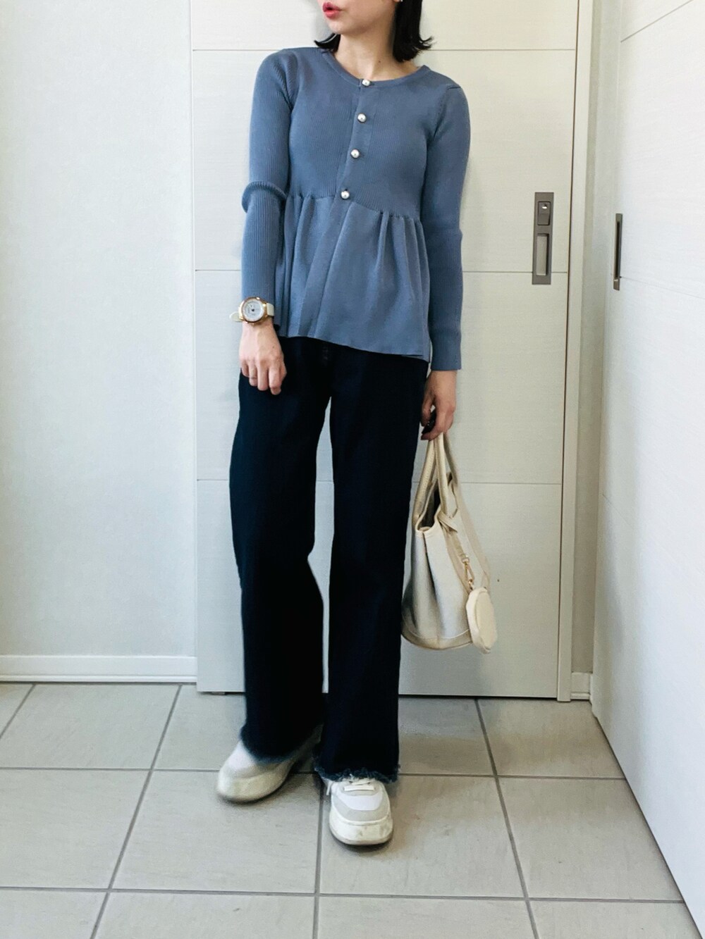 グレー系のカーディガン/ボレロ、ブルー系のデニムパンツ、ホワイト系のスニーカーを着用したレディースの春コーディネートの4枚目の写真