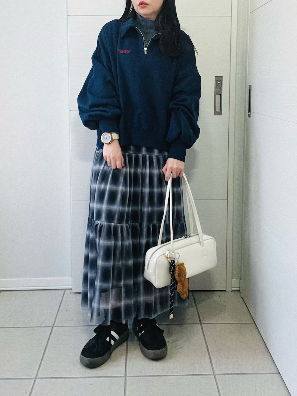 ブラック系のスカート、ブルー系のスウェット、ホワイト系のボストンバッグを着用したレディースの秋コーディネートの2枚目の写真