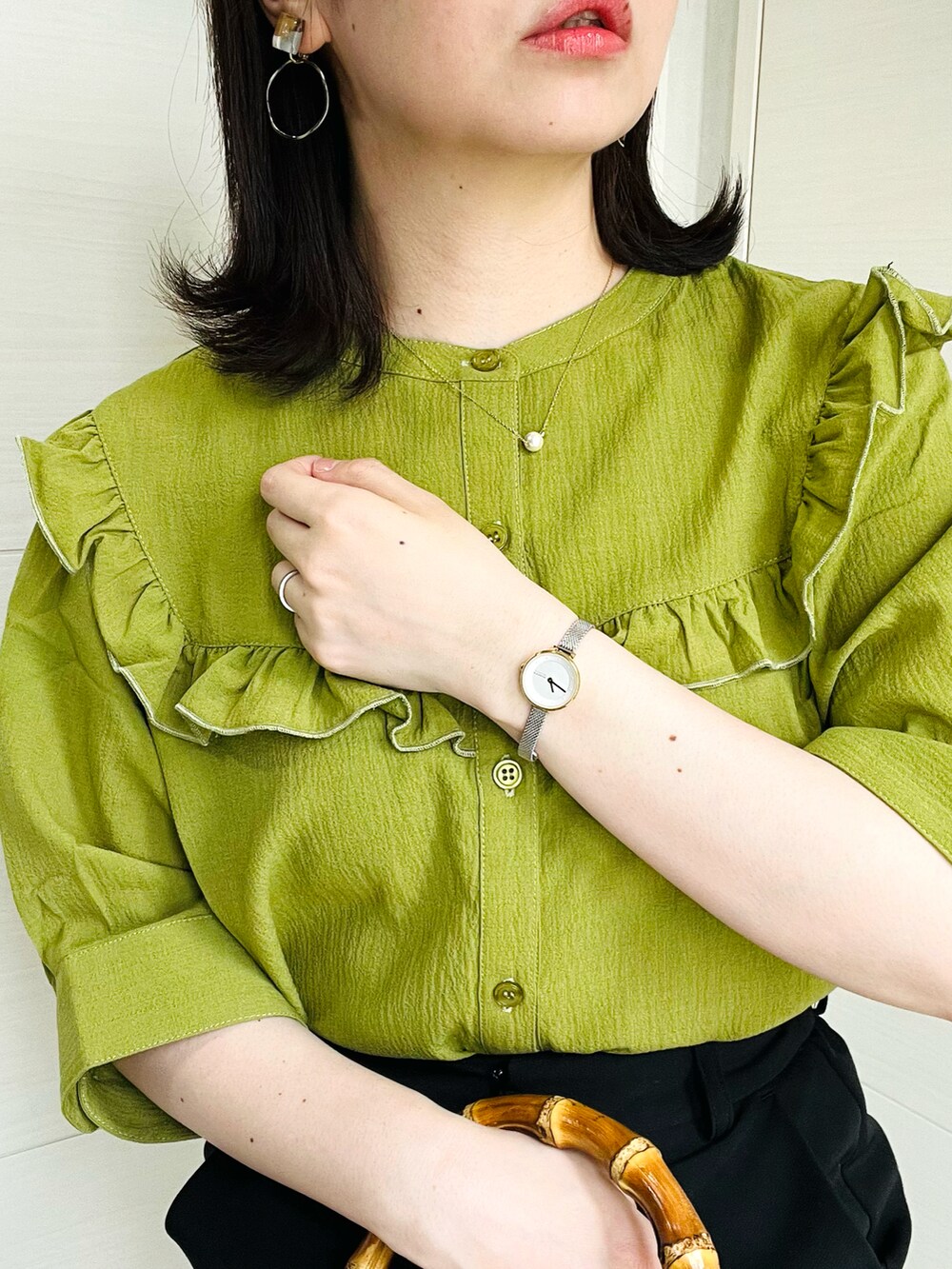 グリーン系のシャツ/ブラウス、ブラック系のスラックス、ブラック系のサンダルを着用したレディースの夏コーディネートの3枚目の写真