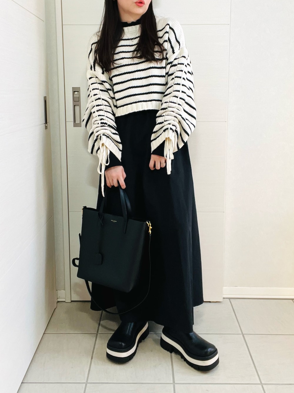 その他のニット/セーター、グリーン系のワンピース、ブラック系のブーツを着用したレディースの冬コーディネートの4枚目の写真