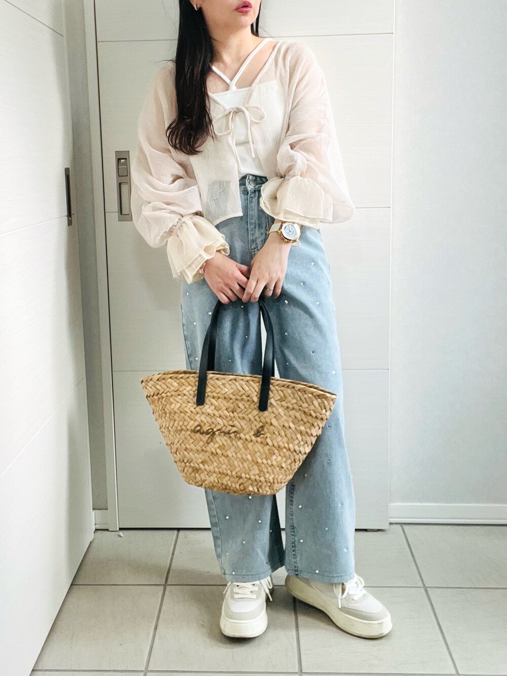 ベージュ系のカーディガン/ボレロ、ホワイト系のキャミソール、ブルー系のデニムパンツを着用したレディースの夏コーディネートの4枚目の写真