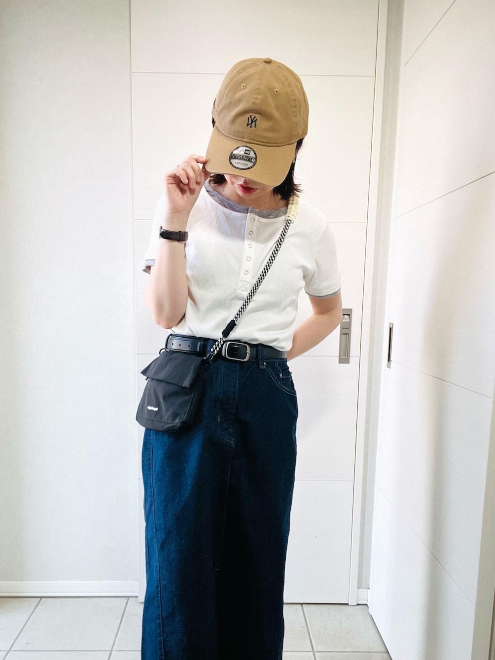 ホワイト系のTシャツ/カットソー、ブルー系のスカート、グレー系のスニーカーを着用したレディースの春コーディネートの4枚目の写真