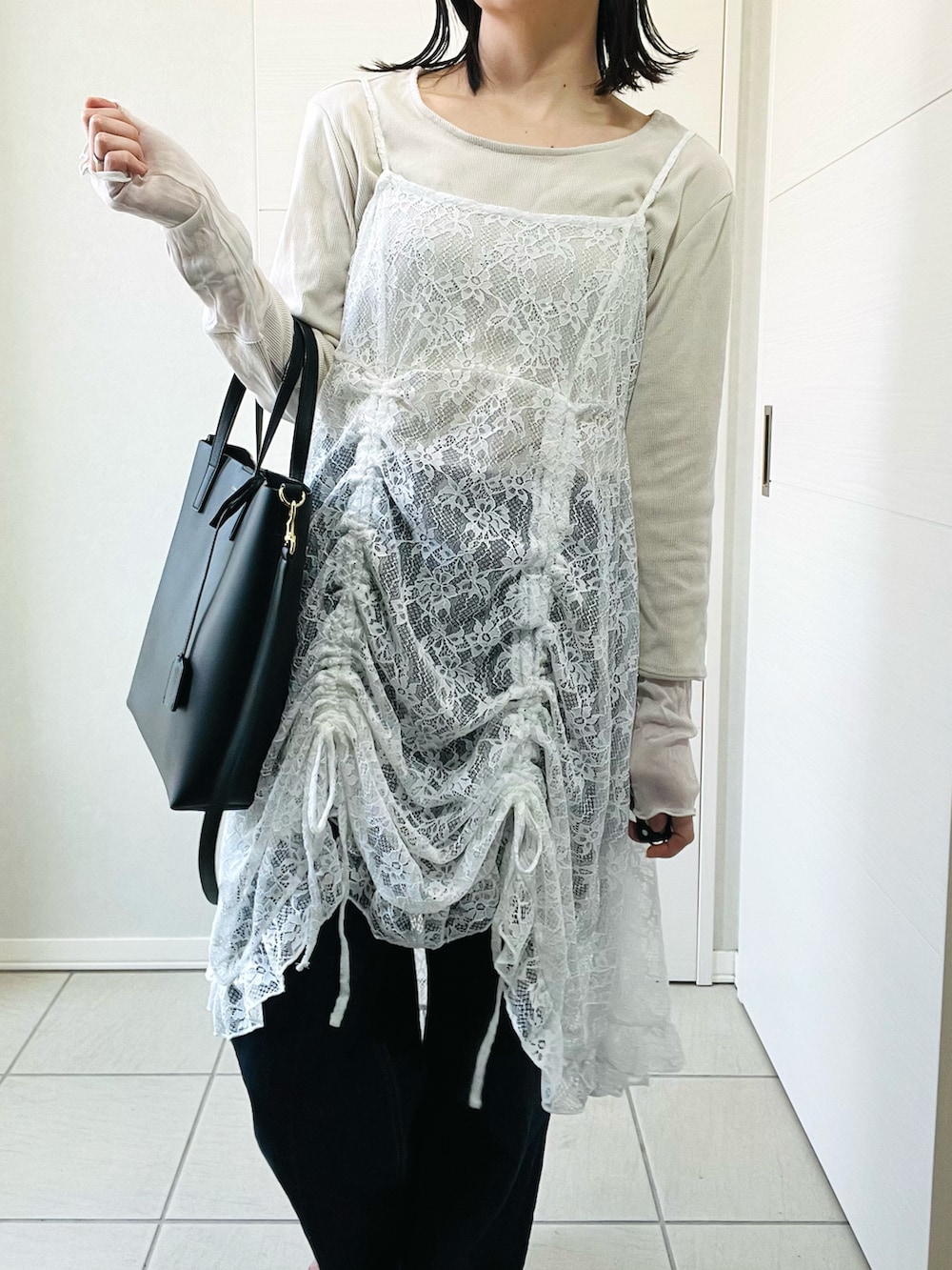 ホワイト系のチュニック、ホワイト系のTシャツ/カットソー、ブルー系のデニムパンツを着用したレディースの春コーディネートの3枚目の写真