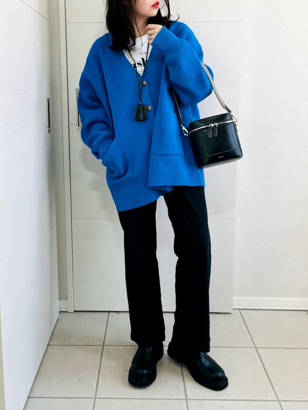 ブルー系のカーディガン/ボレロ、ホワイト系のTシャツ/カットソー、ブラック系のその他パンツを着用したレディースの冬コーディネートの2枚目の写真