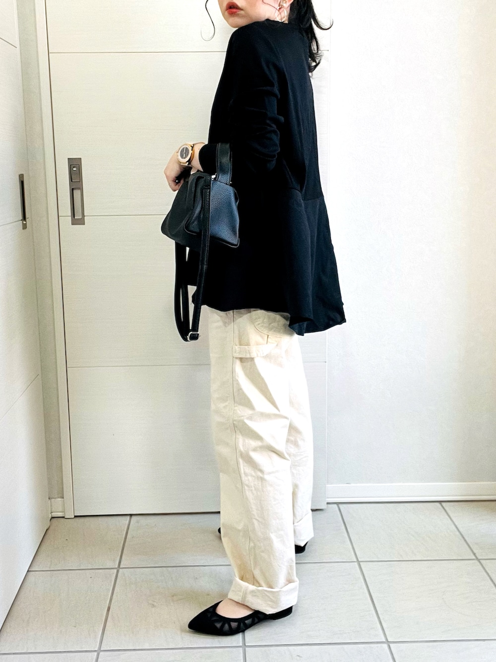 ブラック系のTシャツ/カットソー、ホワイト系のデニムパンツ、ブラック系のパンプスを着用したレディースの春コーディネートの3枚目の写真