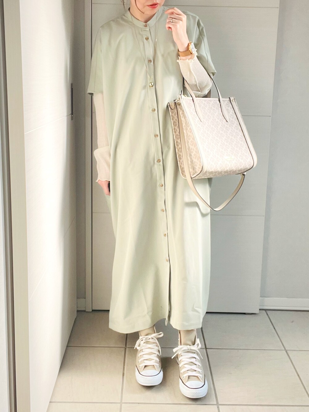 グリーン系のワンピース、その他のハンドバッグ、ベージュ系のスニーカーを着用したレディースの春コーディネートの2枚目の写真