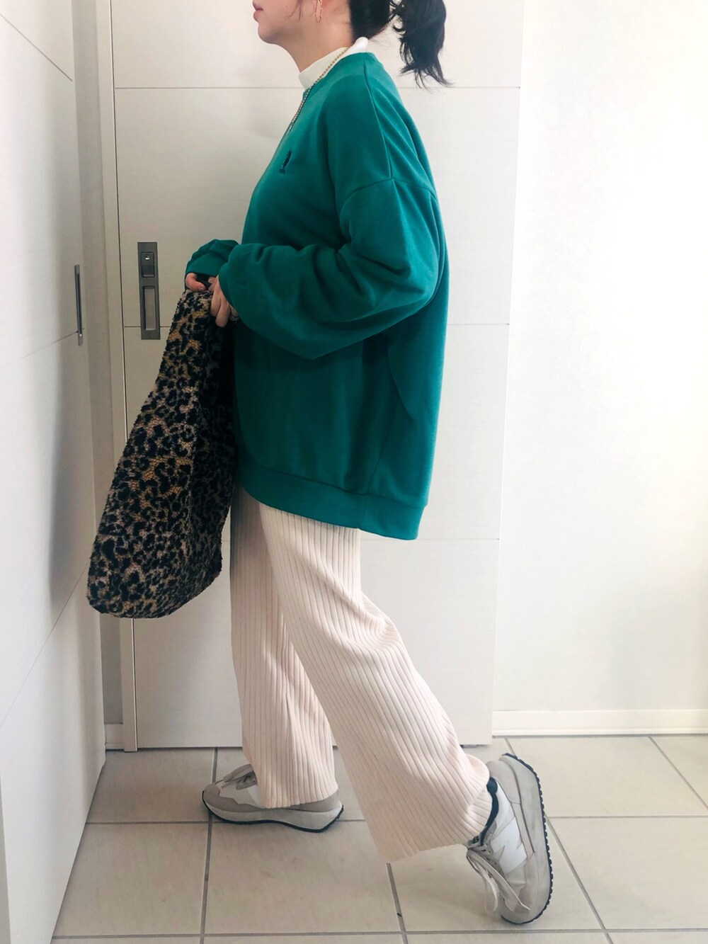 グリーン系のスウェット、ホワイト系のその他パンツ、ホワイト系のスニーカーを着用したレディースの冬コーディネートの3枚目の写真