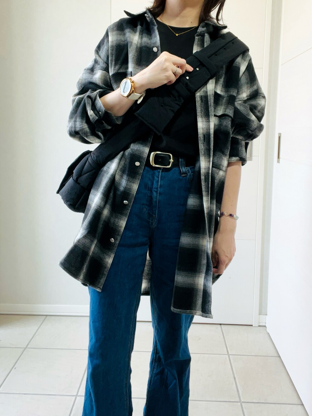 ブラック系のスニーカー、ブラック系のシャツ/ブラウス、ブラック系のTシャツ/カットソーを着用したレディースの秋コーディネートの2枚目の写真