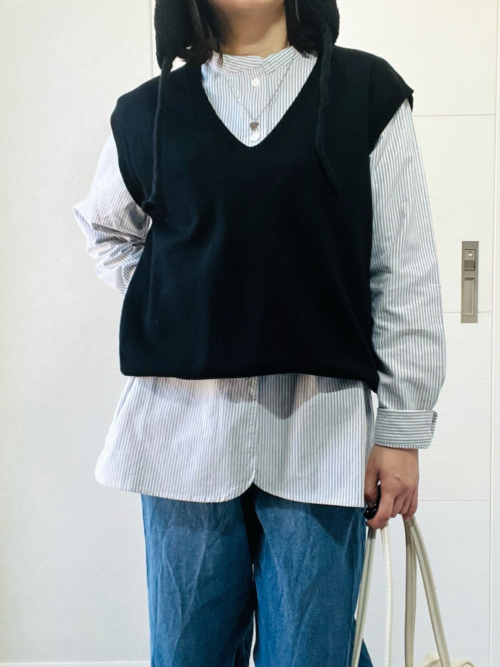 ブラック系のシャツ/ブラウス、ブルー系のデニムパンツ、ベージュ系のスリッポンを着用したレディースの秋コーディネートの3枚目の写真