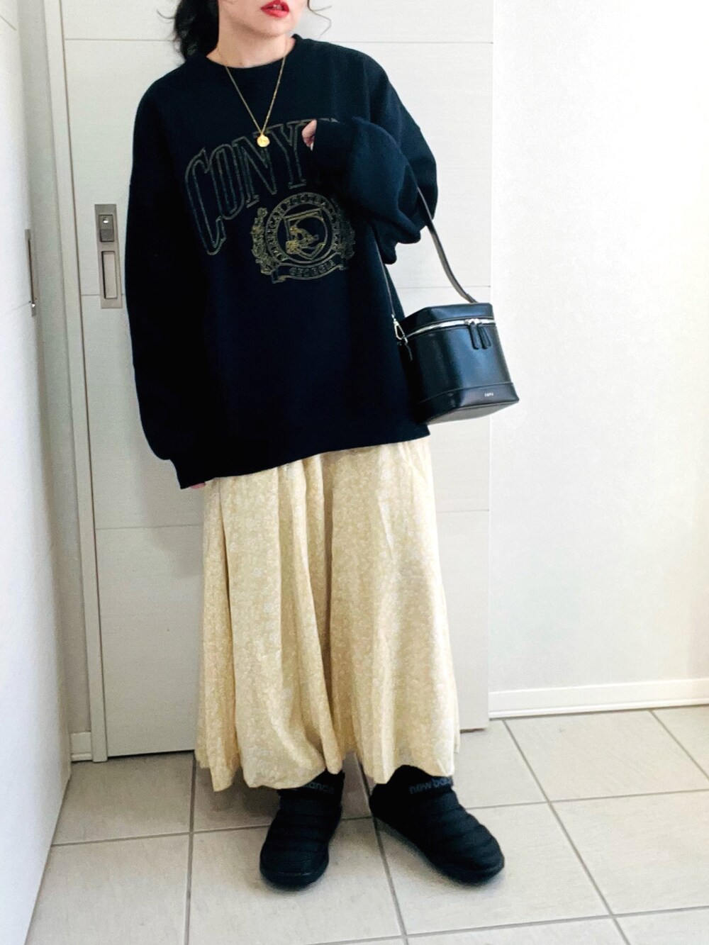 ブルー系のスウェット、イエロー系のスカート、ブラック系のスニーカーを着用したレディースの冬コーディネートの2枚目の写真