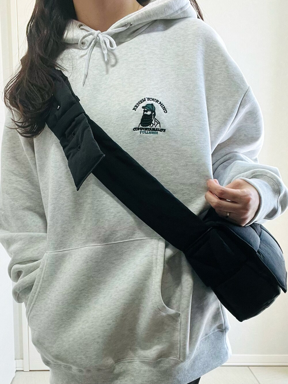 グレー系のパーカー、ブラック系のローファー、ブラック系のショルダーバッグを着用したレディースの春コーディネートの3枚目の写真