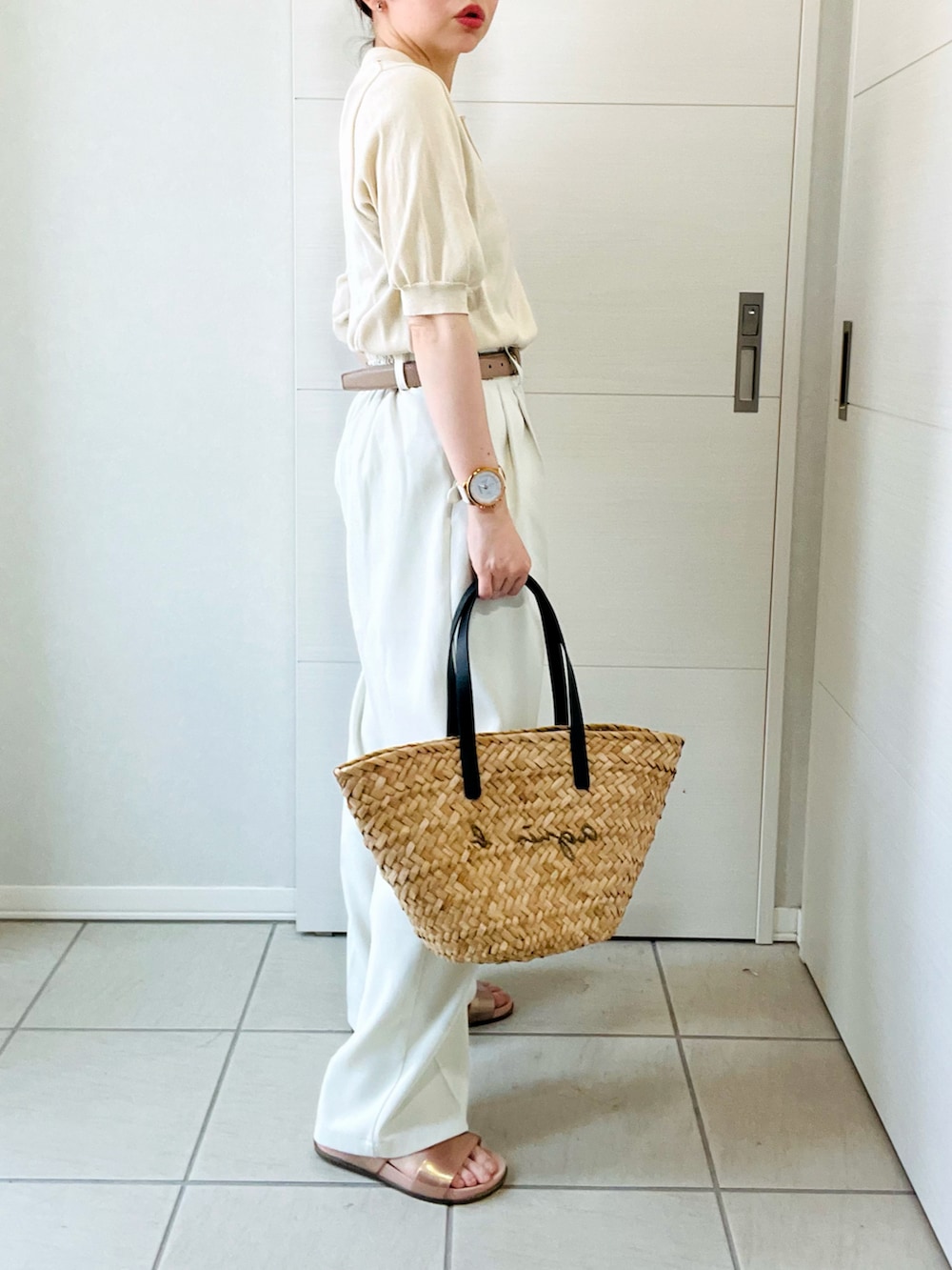 ホワイト系のポロシャツ、ホワイト系のスラックス、ブラック系のかごバッグを着用したレディースの夏コーディネートの4枚目の写真