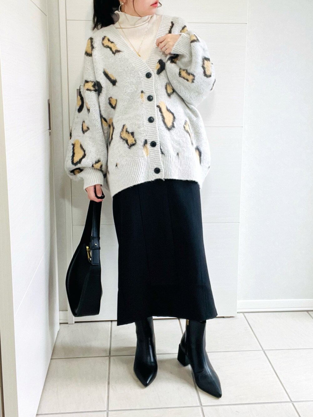 その他のカーディガン/ボレロ、ホワイト系のニット/セーター、ブラック系のスカートを着用したレディースの秋コーディネートの2枚目の写真