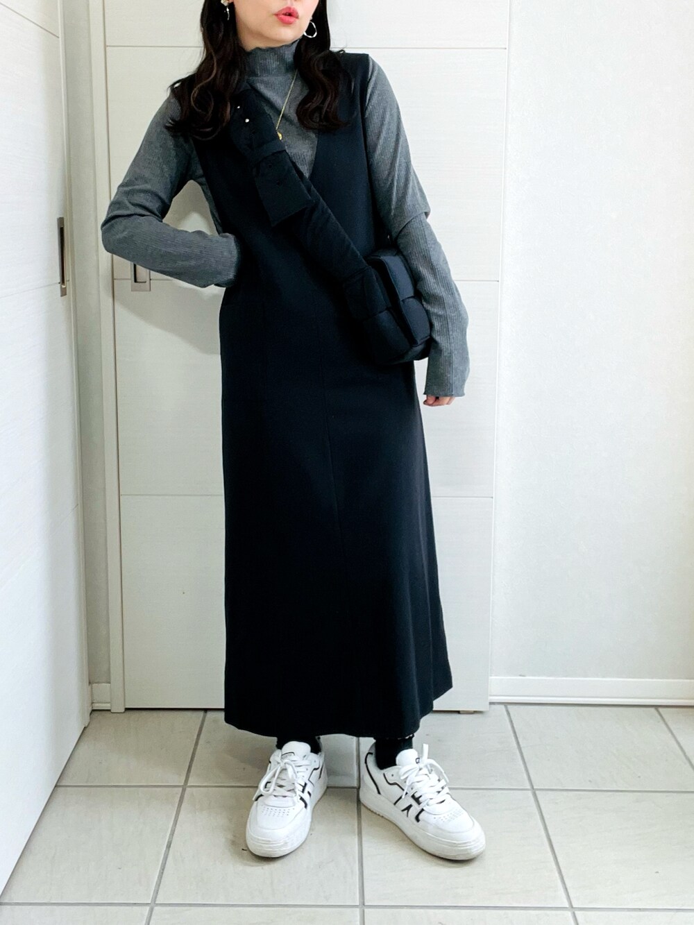 グレー系のTシャツ/カットソー、ブラック系のスカート、ホワイト系のスニーカーを着用したレディースの秋コーディネートの4枚目の写真