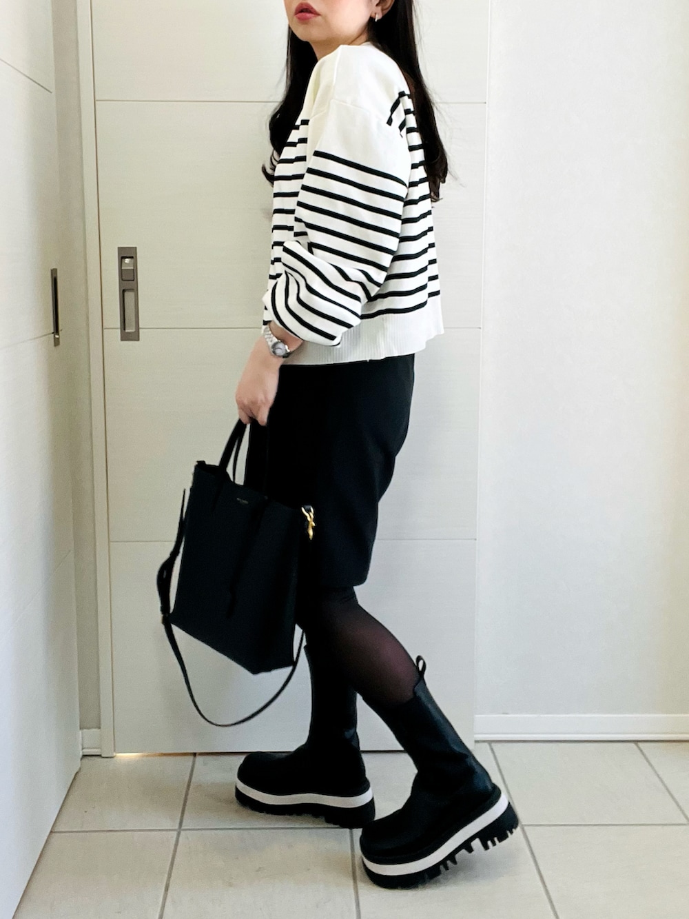 ホワイト系のカーディガン/ボレロ、ブラック系のその他パンツ、ブラック系のブーツを着用したレディースの冬コーディネートの5枚目の写真