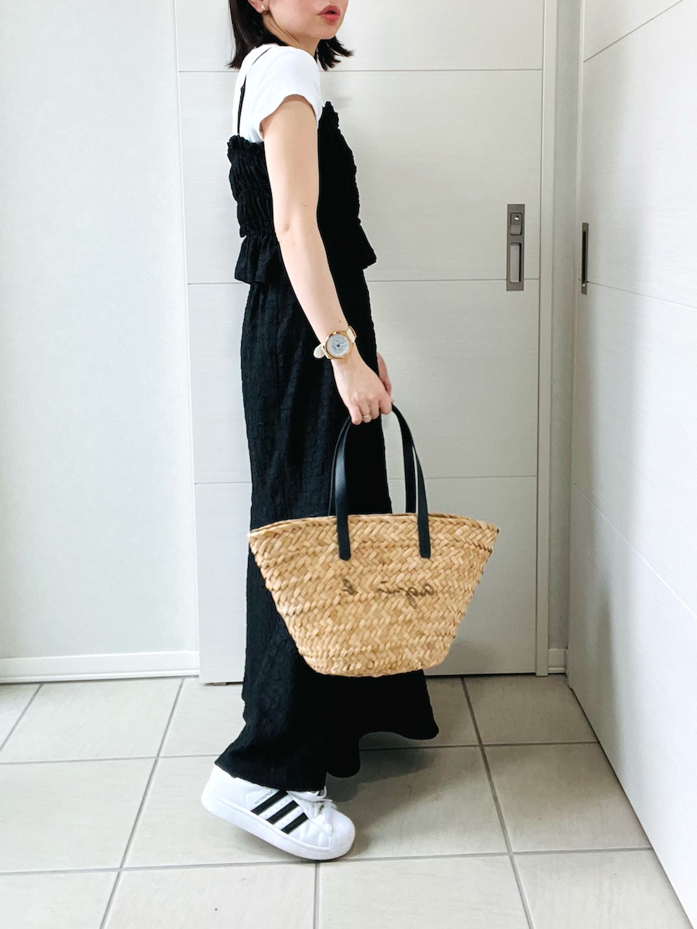 ブラック系のワンピース、ホワイト系のスニーカー、ブラック系のかごバッグを着用したレディースの夏コーディネートの5枚目の写真