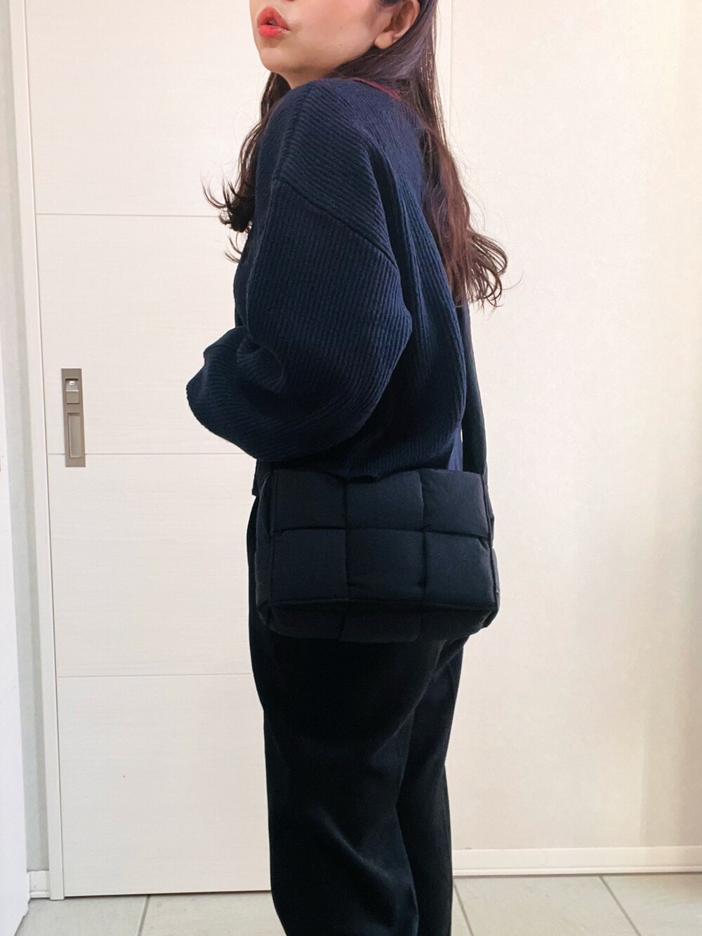 ブルー系のニット/セーター、ブラック系のスラックス、ベージュ系のスリッポンを着用したレディースの冬コーディネートの4枚目の写真