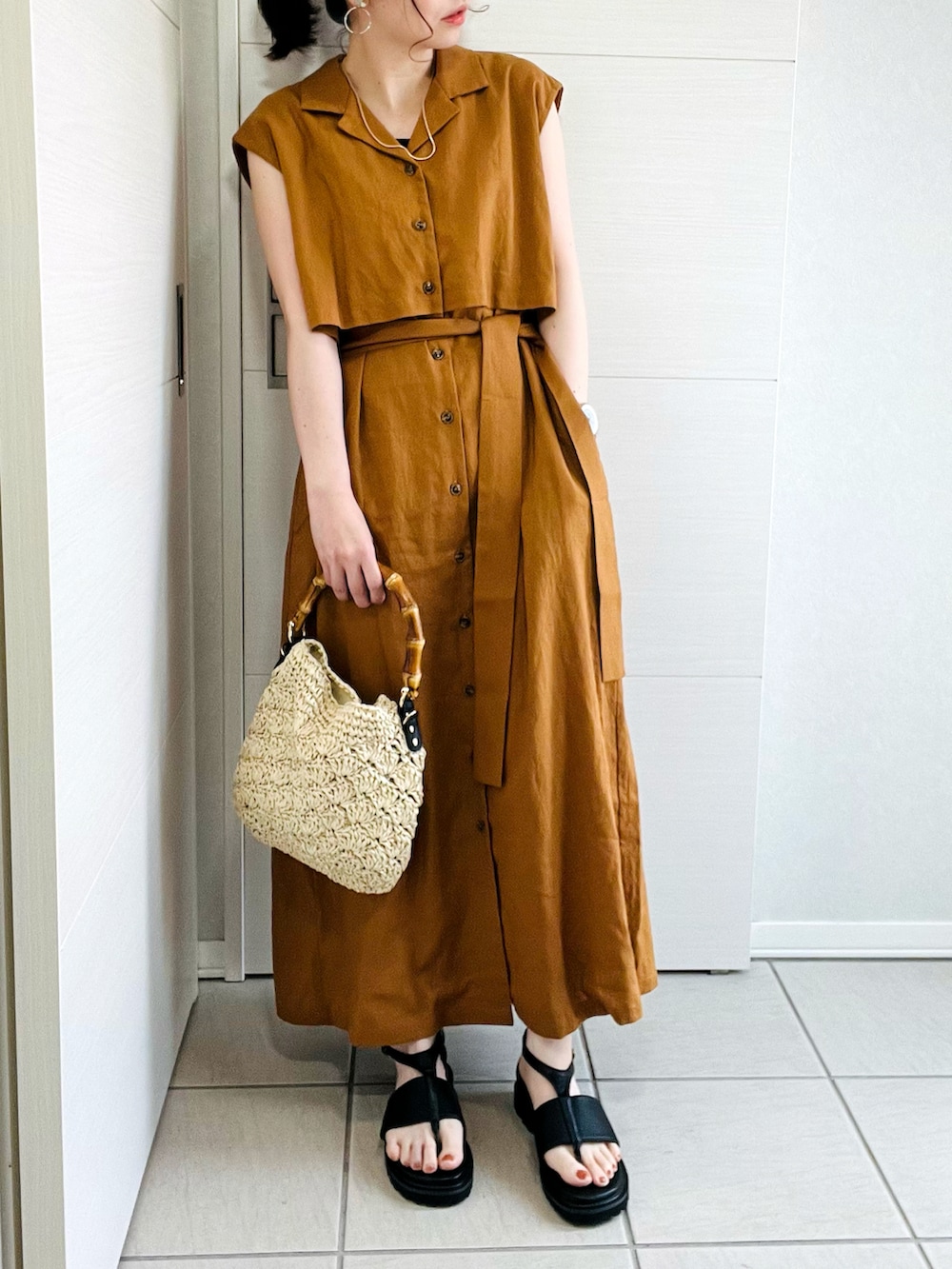 ブラウン系のワンピース、ブラック系のサンダル、ベージュ系のショルダーバッグを着用したレディースの夏コーディネートの2枚目の写真